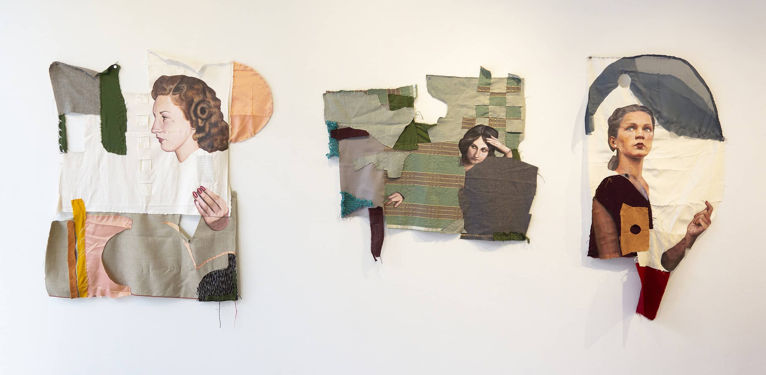 Three textile collage artworks on a white gallery wall, each featuring painted figures integrated with layered and stitched fabric pieces