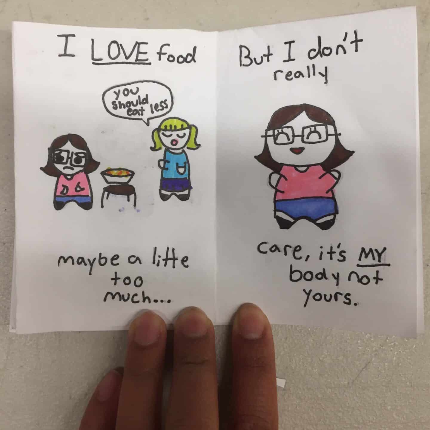 A hand holds a drawing of two girls. One says You should eat less beside food. The other says I LOVE food, maybe a little too much... But I dont really care, its MY body not yours. Perfect inspiration for art enrichment or creative workshops.