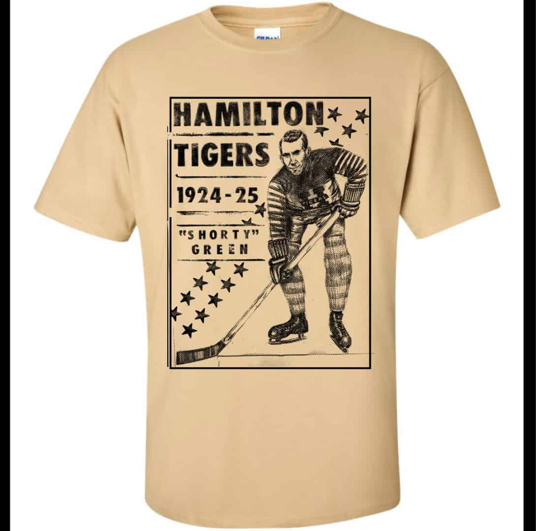 A tan-coloured t-shirt featuring a vintage-style black screen print of "Shorty" Green, a player for the 1924-25 Hamilton Tigers hockey team.